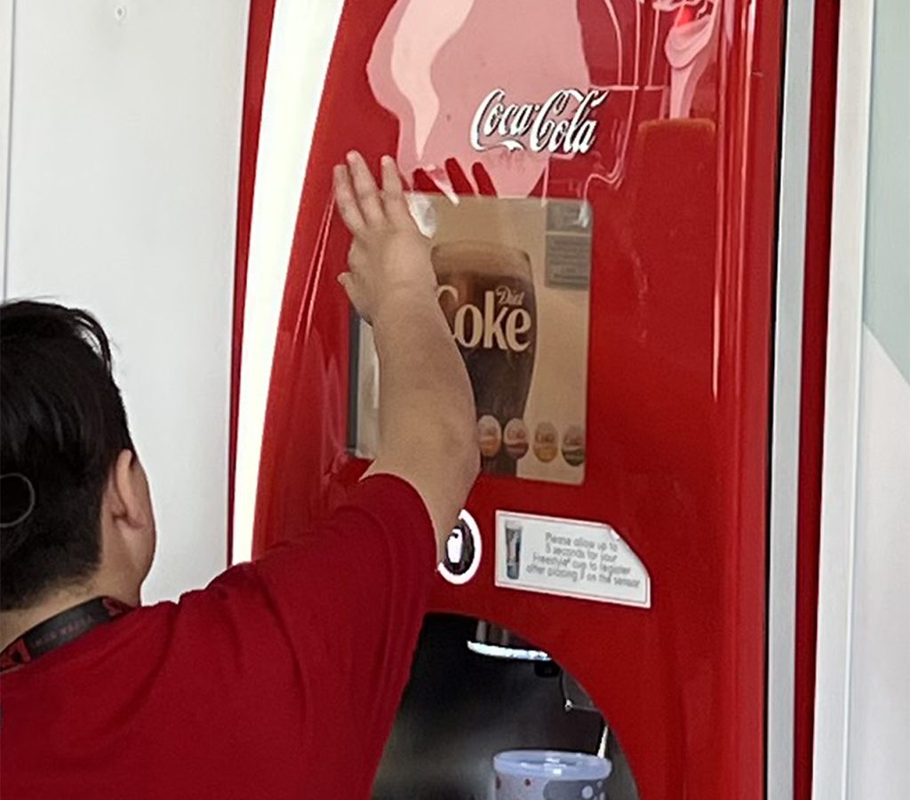 Employee servicing a dispensed beverages machine.