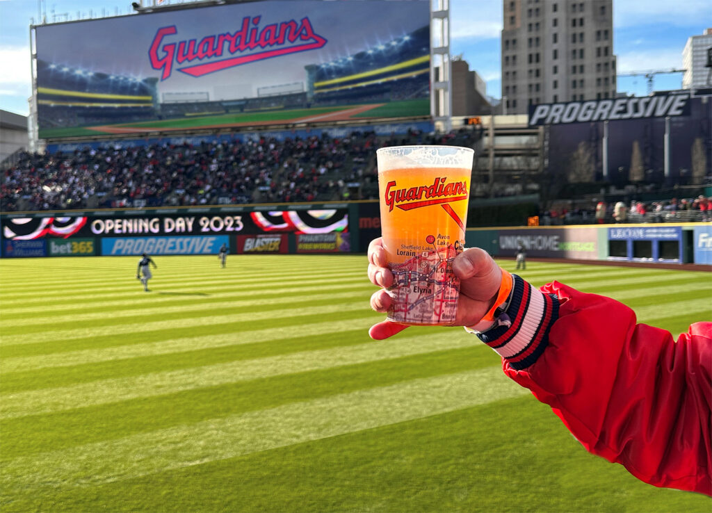 Fan holding a promotional cup at a sporting event.